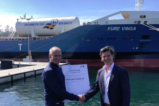 Michael Schaap (right), Commercial Director Marine at Titan LNG, presents Lars Hoglund (left), Furetank's CEO, with a Bio50 LNG certificate.