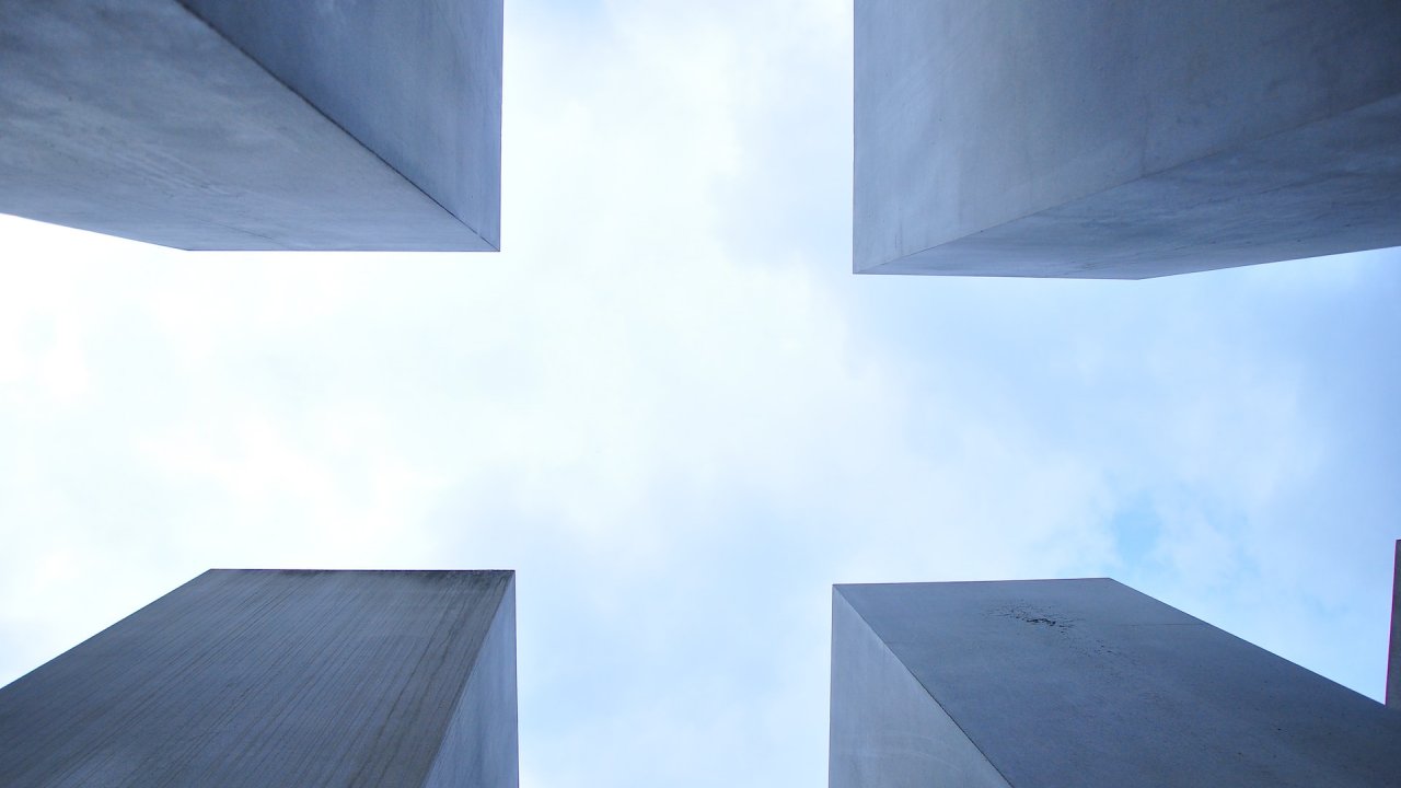 Worm's eye view of four stone structures during daytime.