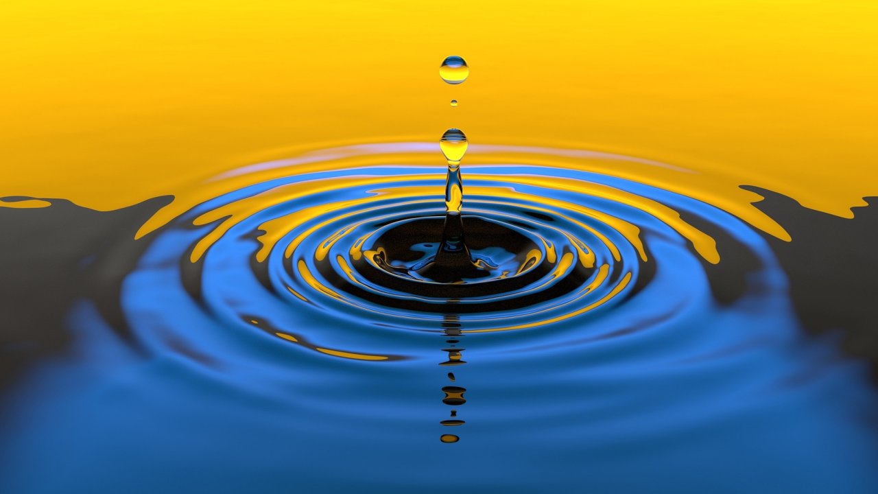 Water drop on body of water, creating a ripple effect.