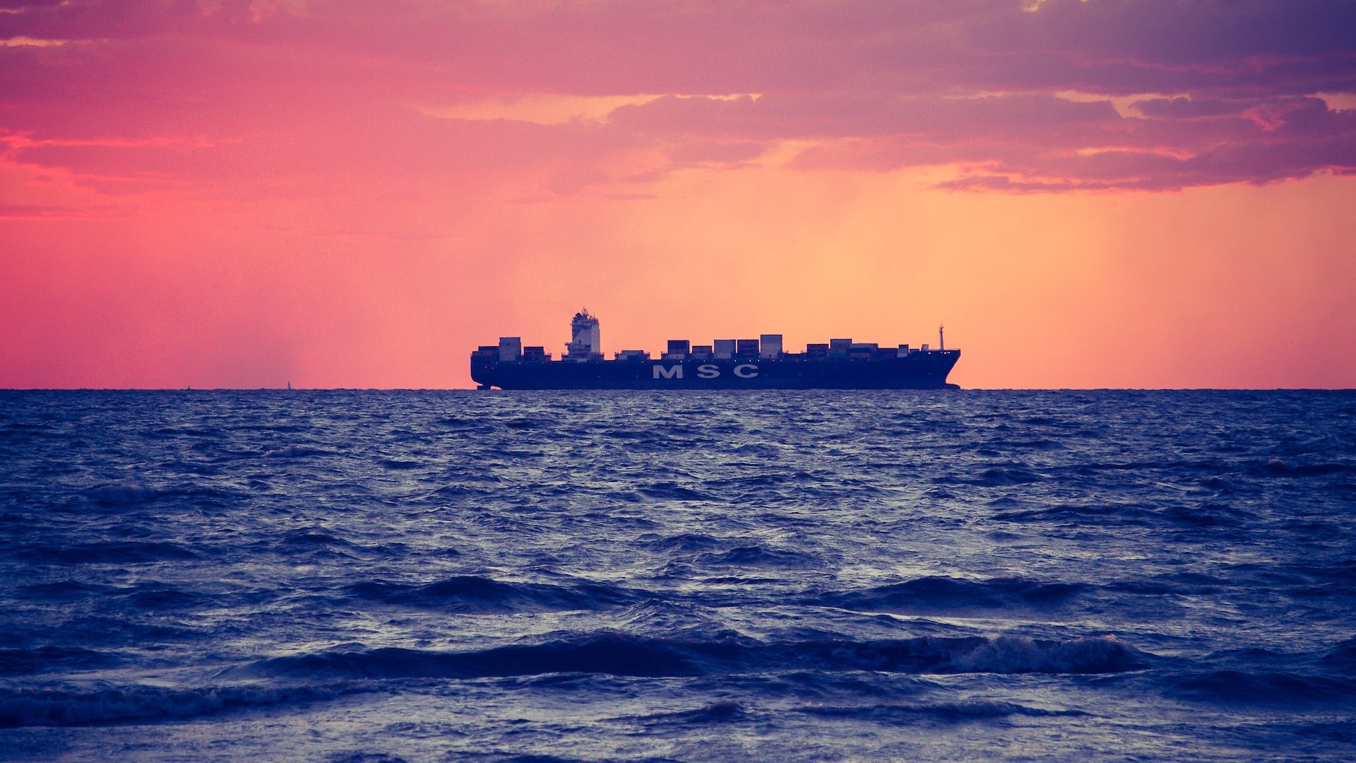 Ship with red sky in background.