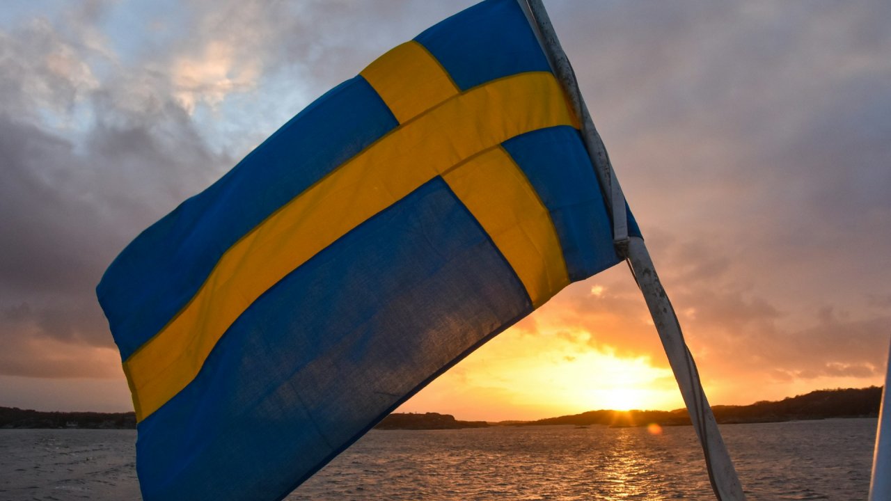 Sweden flag with water in background.